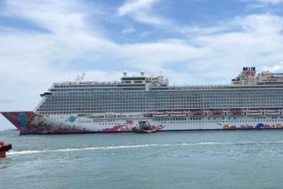 A grand cruise ship sails while passengers enjoy a nearby boat ride, courtesy of Atria Tourist.