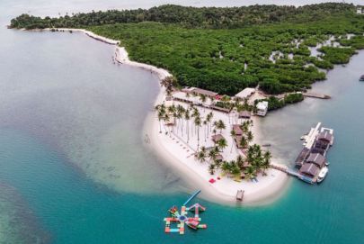 Stunning island view with a boat, showcasing Atria Tourist's amazing travel options.