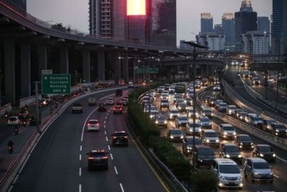 Experience vibrant city tours with Atria Tourist—traffic on a highway at dusk with skyline silhouettes.